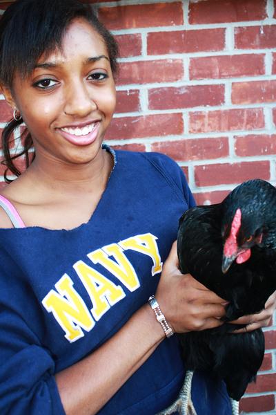 Briyana Theordore 12 embraces a chicken that her and her family have raised. | Photo by Lucas Hammerman