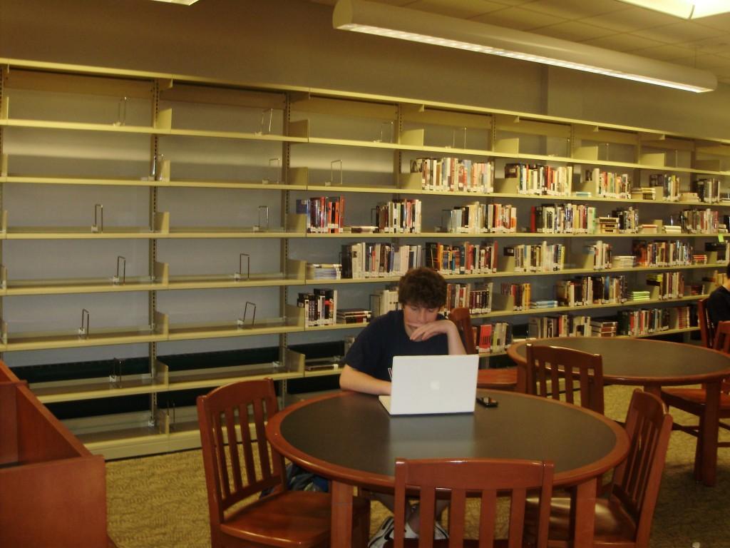 Matt Levantin 13 works in the quiet section during the lunch wave. The Library Media Specialits have already begun to take down the books on the shelves in preparation of summer vacation. The library is still waiting for the return of over 430 late items | Photo by DJ Sixsmith 11