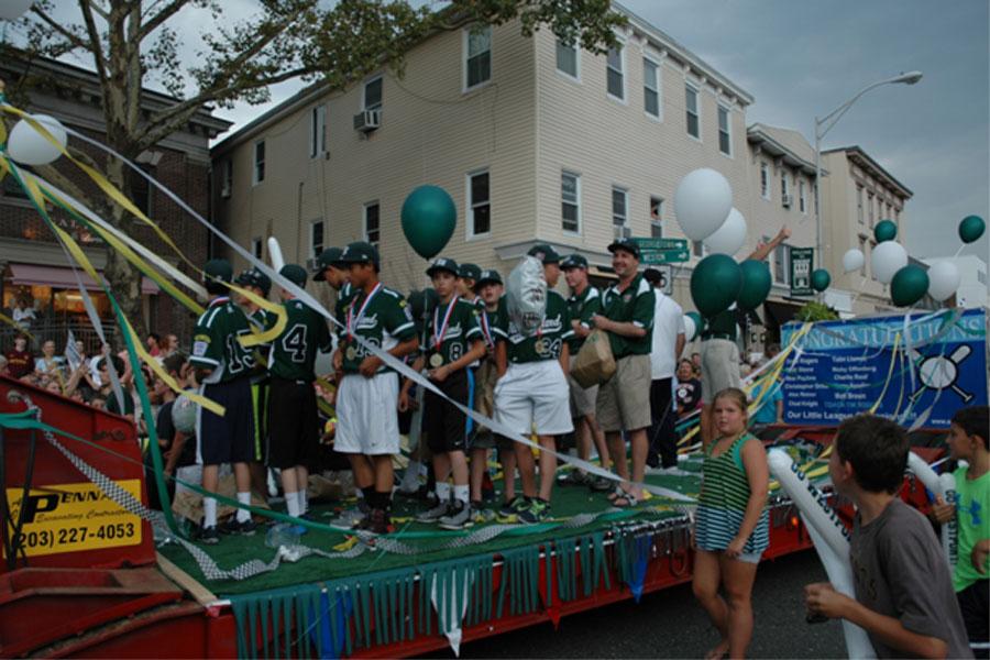 Westport Little League’s 12U team, which is ranked second in the nation for their division, makes their way through town while being celebrated by the lively crowds.
