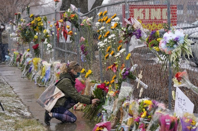A+woman+kneels+with+flowers+to+pay+tribute+to+the+10+victims+of+the+Boulder%2C+Colorado+shooting+on+March+22.