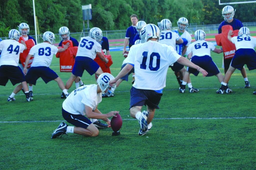 During an early morning preseason practice session, Chester Pajolek 11 holds the football while Kosta Papadopoulos 11 starts his kick |Photo by Petey Menz 11