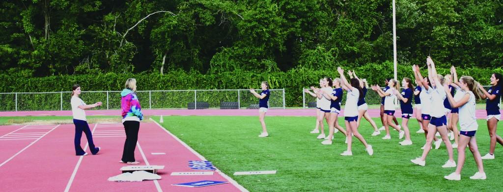 Photo By Annie Nelson 11 - New Varsity Coach,  Denise Dargel leads the Staples varsity cheerleaders in a practice cheer.