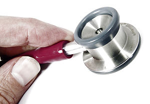 A stethoscope and partial hand.