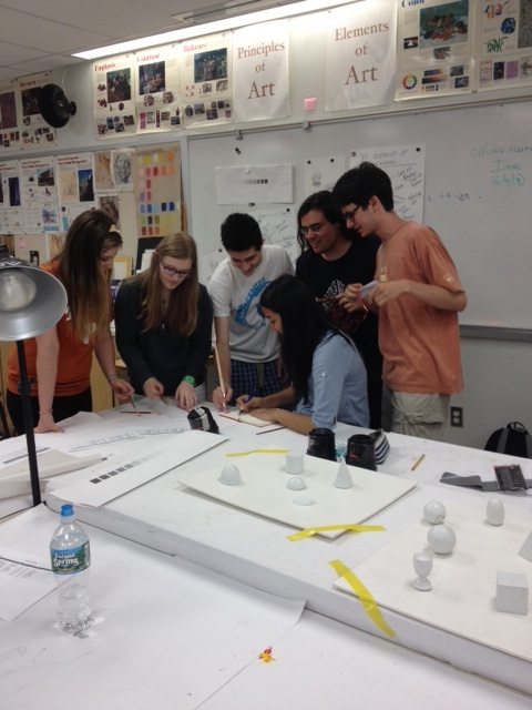 Members of the art club gather around for a meeting 