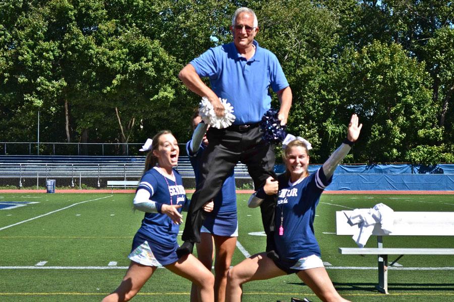 Principal John Dodig, Eliza Yass 14, and Emma Mikesh 14 strike a cheerleading pose.  