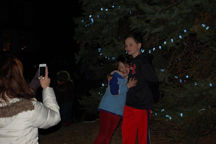 Siblings smile bright for their mother in front of the lit tree. Many families took the photo opportunity and flashed their cameras to capture the memories. 