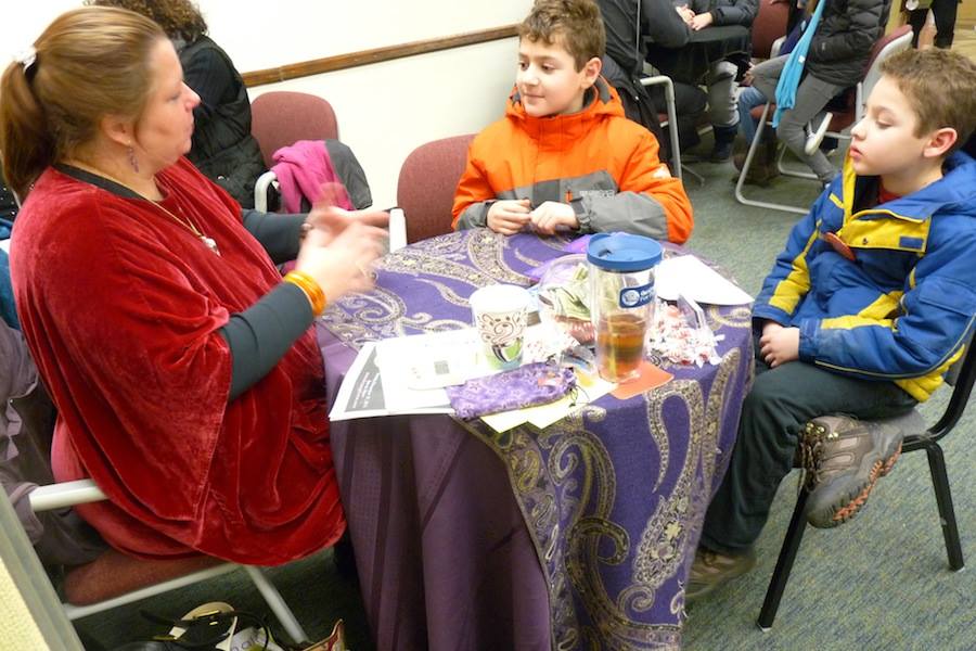 (From Left) David Levine, 11, and his little brother Ben, 8, discover what Alethea Jacob sees in her cards for their futures.