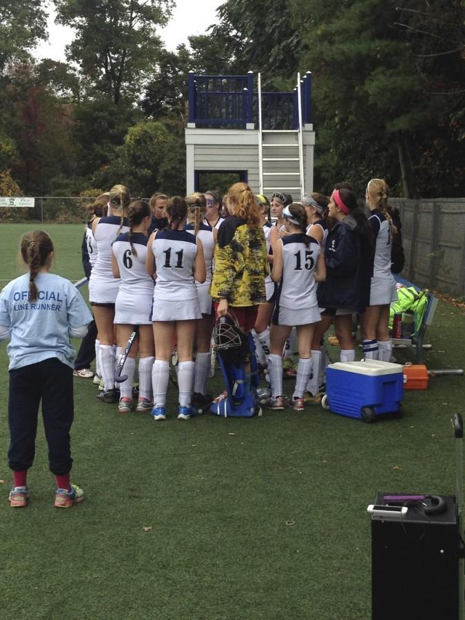 Players huddle around coach Ashley Delvecchio just before the game. Delvecchio preaches, “Let’s get a shutout.”