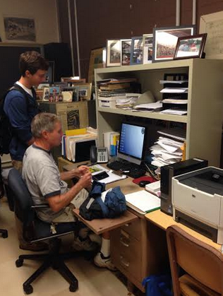 Captain Jake Berman ’15 and Coach Laddie Lawrence discuss the upcoming FCIAC meet in Coach Lawrence’s office.  