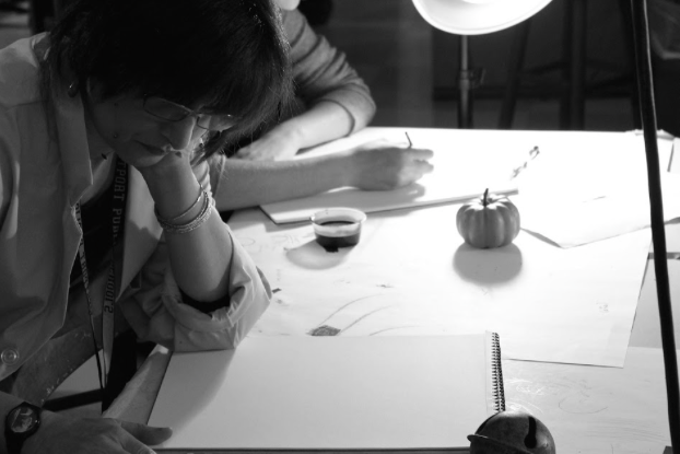 Paint me a picture: With a smile, Camille Eskell admires her students’ artwork. She has taught art classes for 14 years. Eskell has various quirky props in her classroom, like a fake skull.
