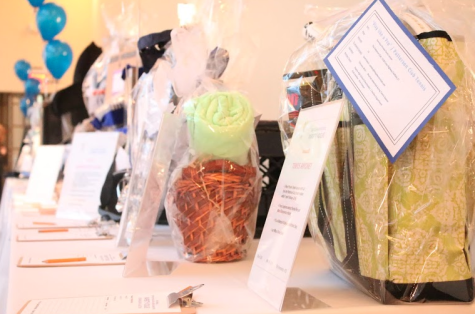 Dozens of silent auction items line the perimeter of the room. The parents put together various themes of baskets, to auction and raffle off in support of the cheerleading team.