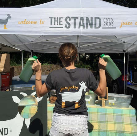 Kowalsky holding “The Stand(ard)” green juice at the Westport Farmer’s Market. 
(Photo contributed by Mikaela Dedona)