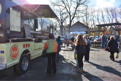 People enjoy food from the food trucks at the local Westport Farmers Market.