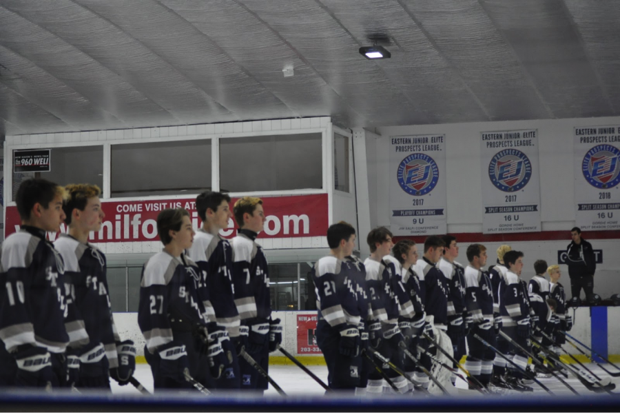 Staples boys hockey team stands for the national anthem prior to their game. 