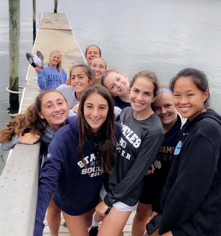 Girls’ soccer team welcomes new members to the team, at beach hangout.