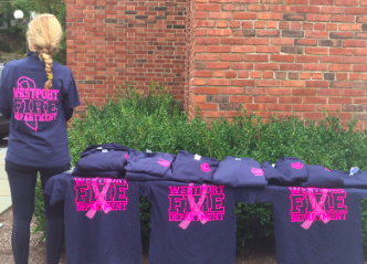 Jennifer Petrosinelli, on behalf of the Westport Fire department, sells breast cancer awareness shirts.