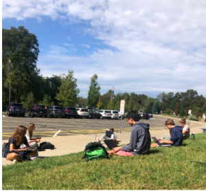 Students in a US History Honors class take advantage of good weather to learn while having a mask break outside.