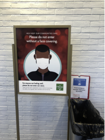 A sign asks customers at “The Fresh Market” to not enter the store without a mask. Signs like these have been seen frequently in front of stores such as Home Goods and Terrain throughout the pandemic.