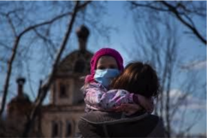 Young girl and her mother head to church with masks to participate in a socially distanced gathering.
