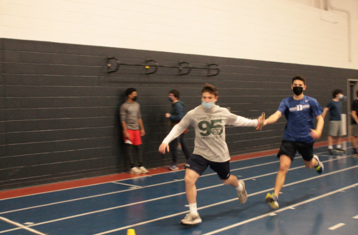 Henry Beck ’21 receives the baton from Konur Nordberg ’21 at a track and field practice. The track team is continuing to compete at a high level in virtual meets while regarding the COVID-19 rules.