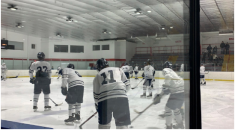 The boys’ varsity hockey team warms up before one of their games. The CIAC hockey program is up and running while maintaining COVID protocols to ensure safety for all players.