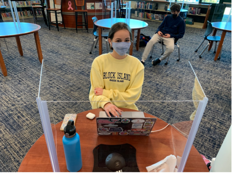 Emma Losonczy ’23 uses music as a way of focusing while studying in the library. The music helps Losonczy  keep her mind awake while she writes an essay for English class. 