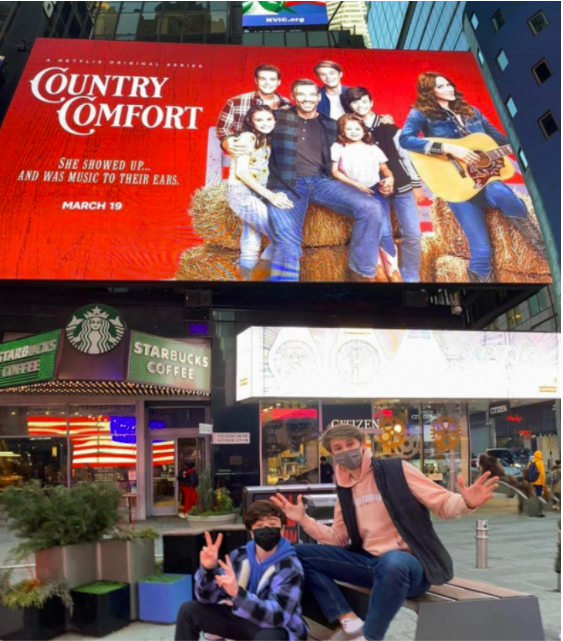 (L-R), Cast members Griffin McIntyre and Jamie Mann ’21 pose in front of the “Country Comfort” billboard in Times Square, New York City.