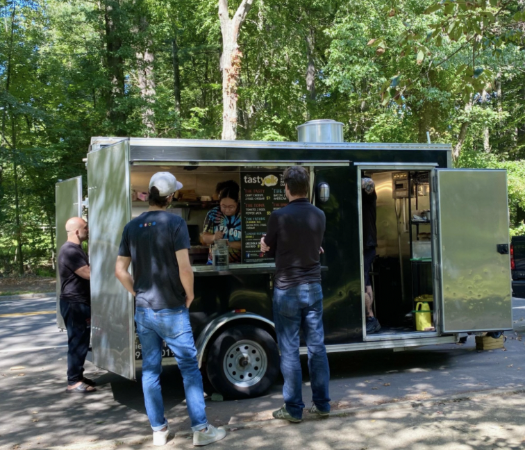 Customers order by the window of The Tasty Yolk food truck in Fairfield while the staff cooks and prepares everything from brussel sprouts to bacon and egg breakfast sandwiches.