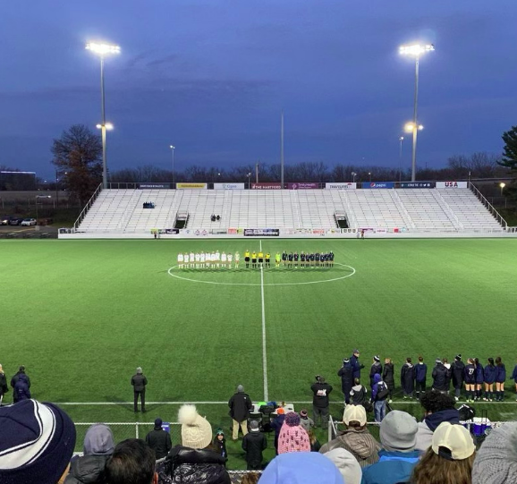 The girls’ soccer team lined up with the opposing team before their semifinal game. This lineup is a tradition before every championship game where they announce the starting lineup.