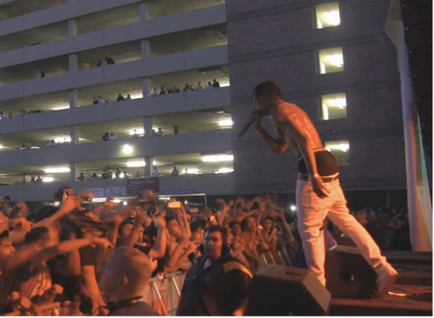 Travis Scott performs for a large crowd, as they press against the gate, while security walks around at a performance in August of 2015. 