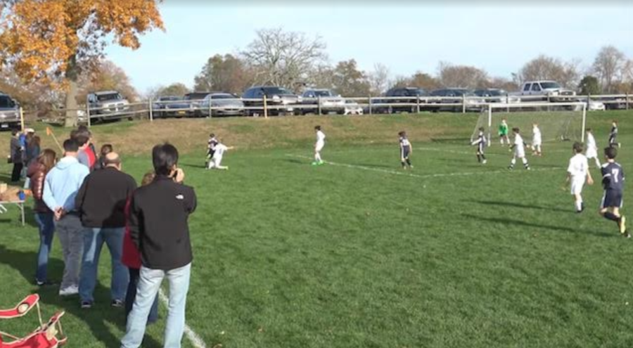 Parents watch a youth soccer match with enthusiasm.