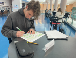 Jack Marshall ’24 diligently works on his assignments outside of the school’s auditorium. 