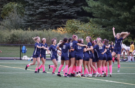 The girls’ soccer team celebrates after a regular season win during their pinkout for breast cancer awareness game. 