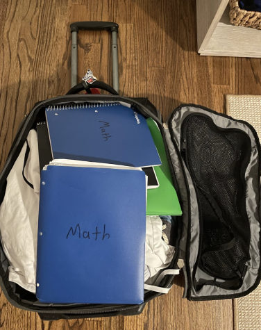 Tristan Gonzalez ’24  packs notebooks in his suitcase so he can study for the midterms even whilst on vacation.