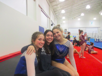 Abbie Pleiter ’25, Victoria Fidalgo ’24 and Eliza Walmark ’25 cheer their teammates on during their meet earlier this season. The Wreckers’ most recent meet against Wilton was a major success, as the team scored almost 2 points higher than their highly ranked competition. 