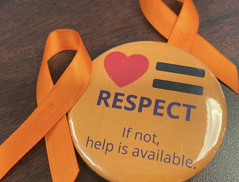 Orange buttons and ribbon pins were distributed to students in the library. Shirts displayed the pins to represent  their awareness of teen dating violence and support for victims. 
