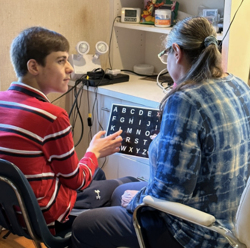 Elisa Feinman, behavior therapist, aids Browne in communication. Feinman helped deliver Browne’s heartfelt Father’s Day card.