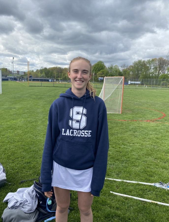 aroline Cooper ’24 poses in her Staples lacrosse gear at team photo day
