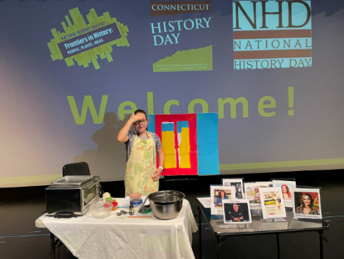 Camille Merganthaler ’25 sets up a table with images to represent women in the culinary industry and provide a place for her to bake her cookies. 
