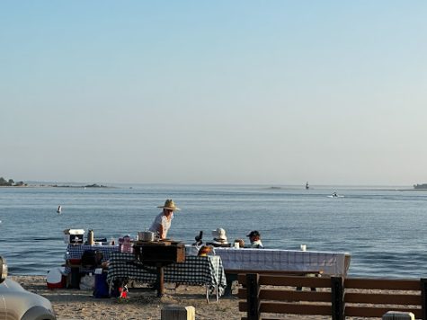 For various occasions, lots of people set up full blown picnics along the shores of Compo Beach. Here, one woman tends to the multiple tables she sets up and enjoys with her family.