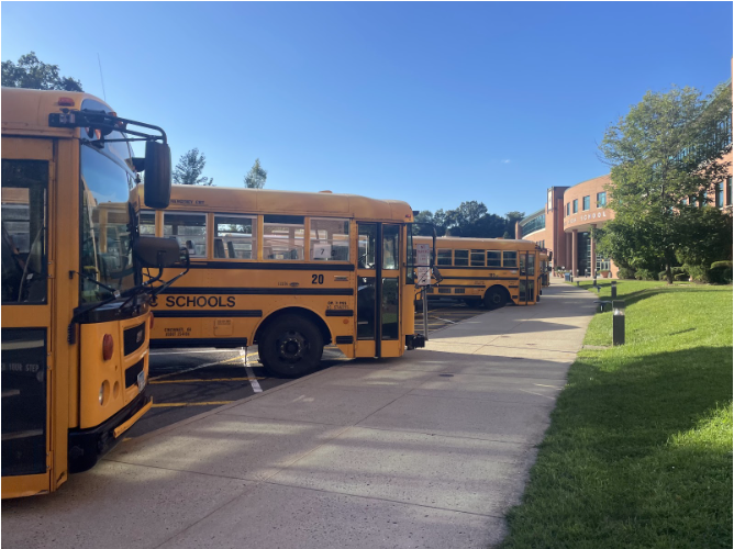 First student buses are parked outside the front of Staples High School. 