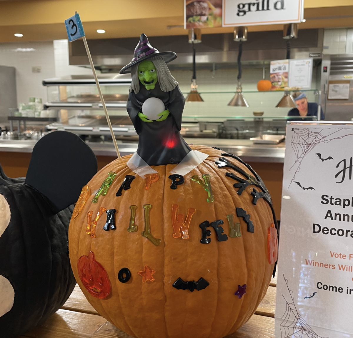 This third pumpkin was decorated by cafeteria server, Anna. The pumpkin was embellished with Gel clings that compliment the holiday spirit, letters that spell out Happy Halloween, and an interactive witch that cackles when the red dot appears.
