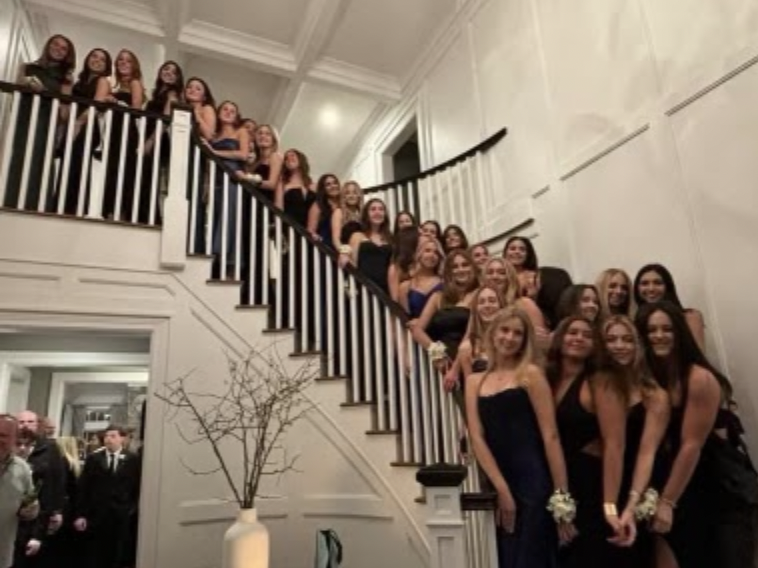 Photo contributed by Robert Harrington. Junior girls line up on the staircase to take a group photo before the dance. 