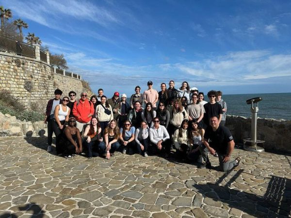 Members on the Staples STEM trip pose in front of Mediterranean Sea. 
