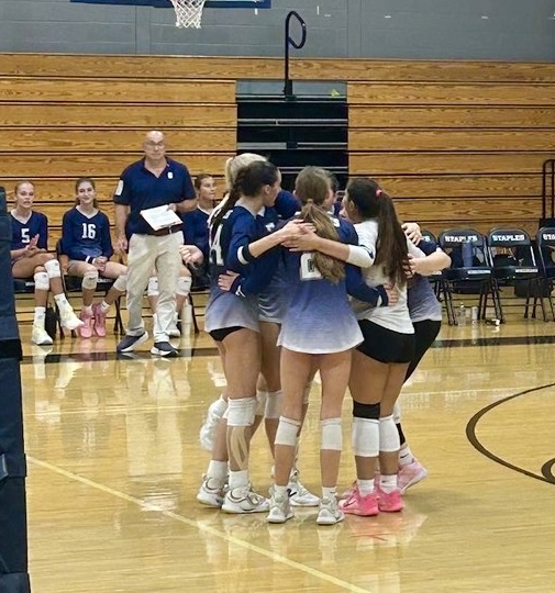 The girls' volleyball team huddles before beginning their final set against Brien McMahon. 