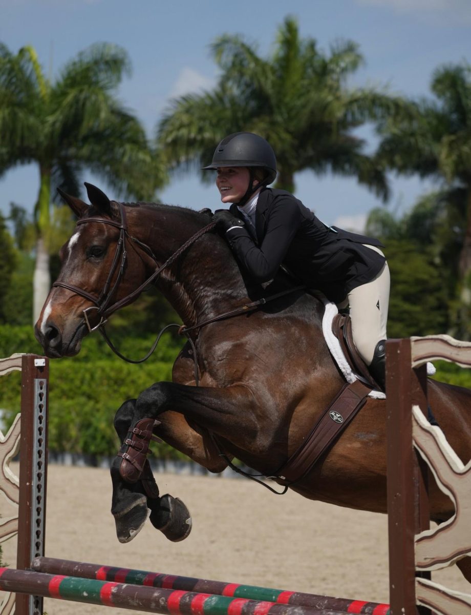 Piper Grove ’26 jumps over an oxer while competing at the Winter Equestrian Festival in Wellington, Florida. 
