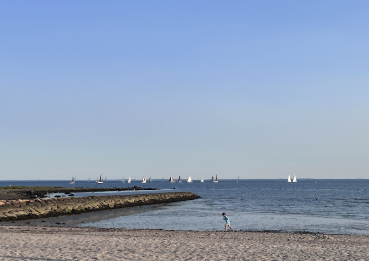 During the summer, people enjoy the sands while boaters sail off the coast of Compo Beach. 