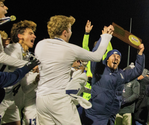 Staples boys' soccer Head Coach Liam Witham celebrates with team after the state championship win.
